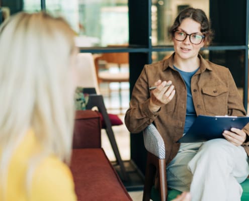 A Female Psychologist Advises A Client. Portrait Of A Professional Modern Woman. HR Hires And Conducts Interviews.